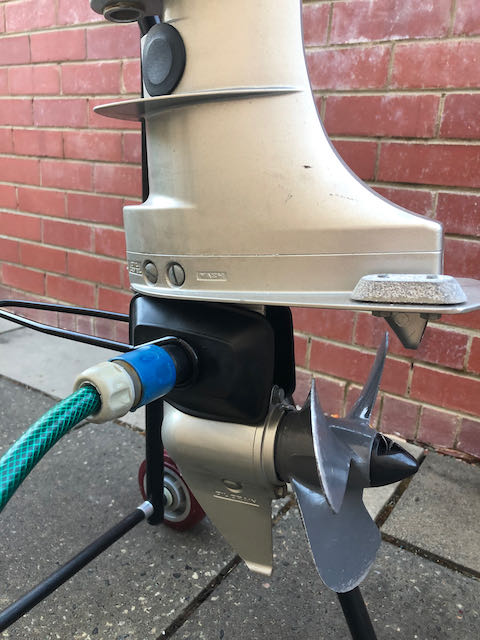 Flushing outboard motor engine while it is secured to the trolley