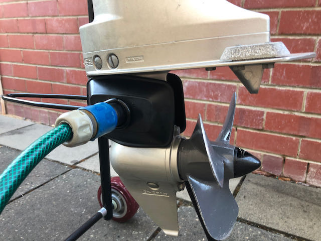 Flushing outboard motor engine while it is secured to the trolley